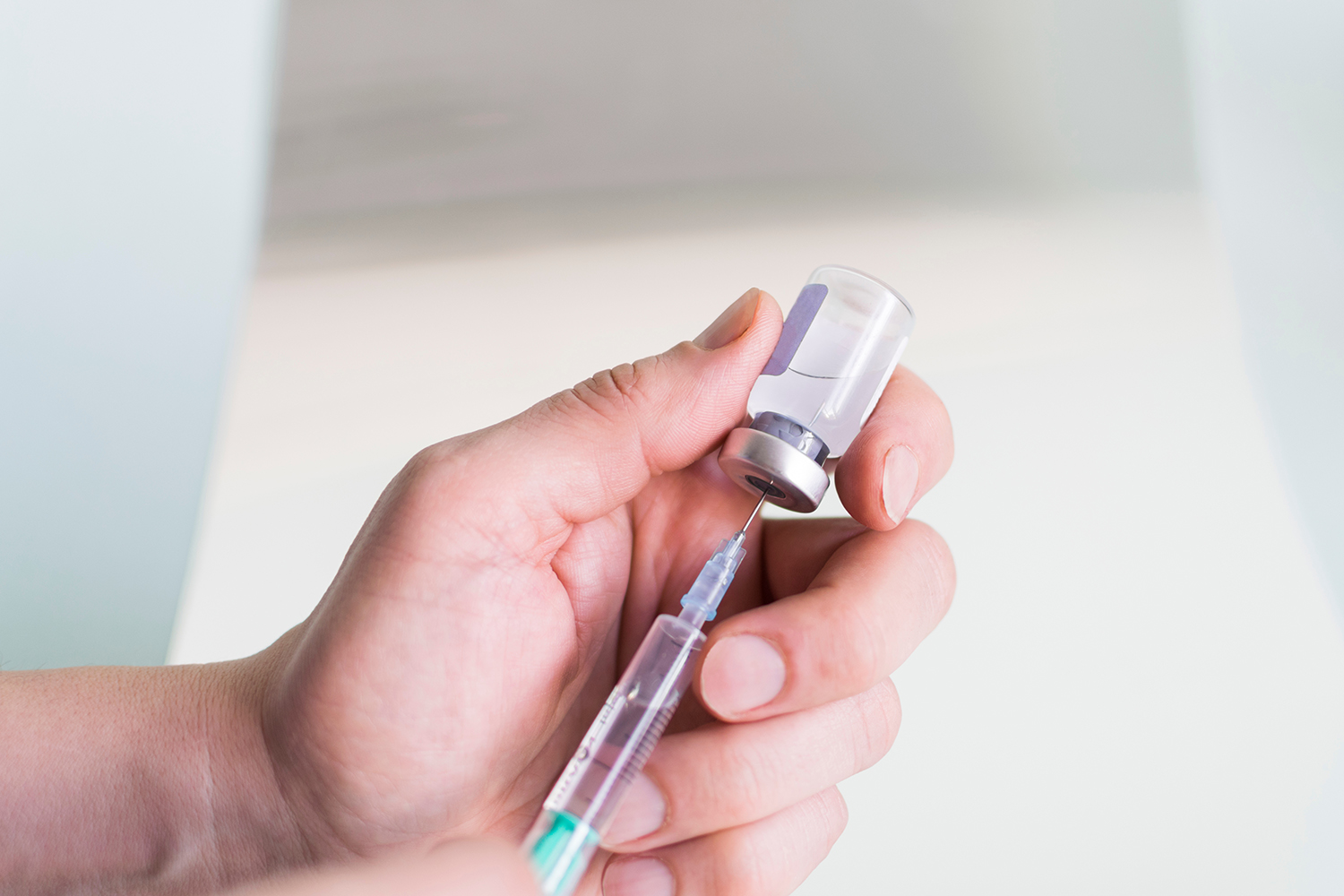 A vile of compounded GLP-1 being drawn up with a needle.