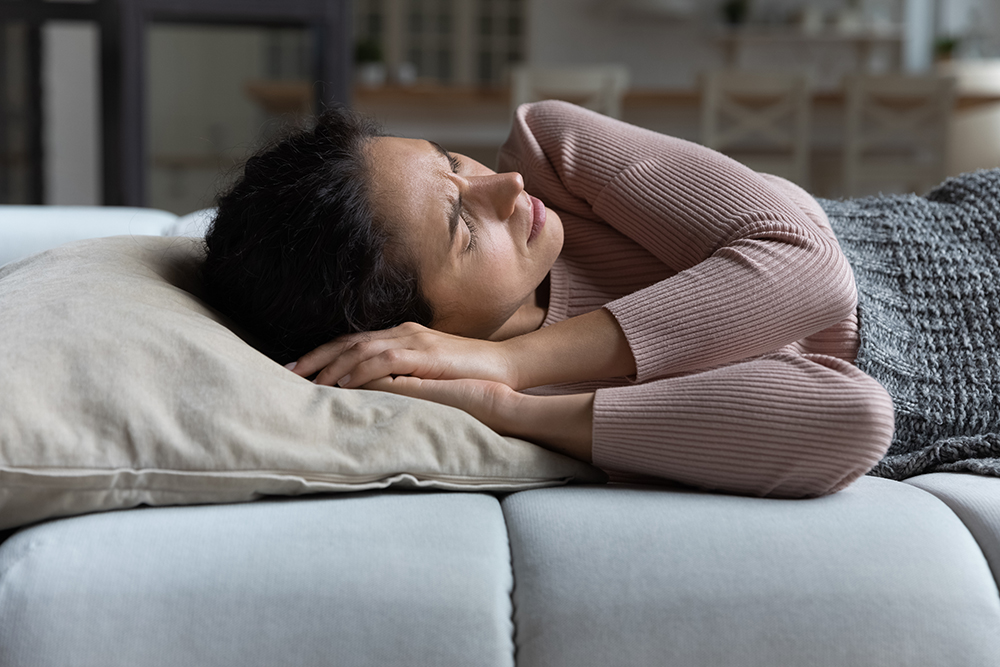 An unwell woman laying in bed.