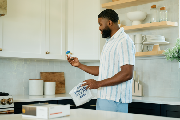 A man evaluates his recently delivered TelyRx prescription.