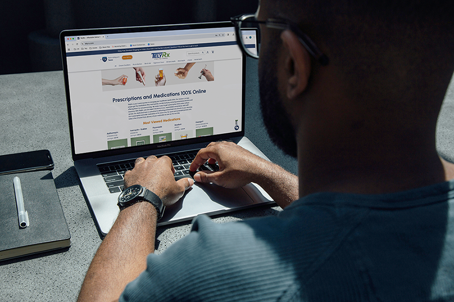 A man browsing the TelyRx website on his laptop.