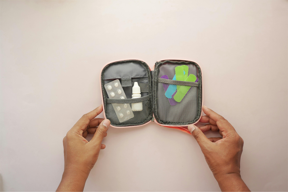 A mini travel first aid kit with bandages, eye drops, and allergy medication.