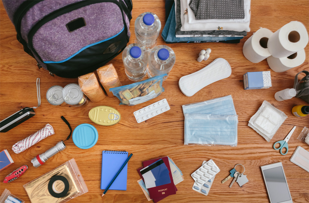 Disaster prep supplies are laid out on a table, including a bag to store them in.