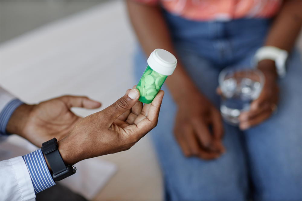 A patient holding a bottle of prescription medication.
