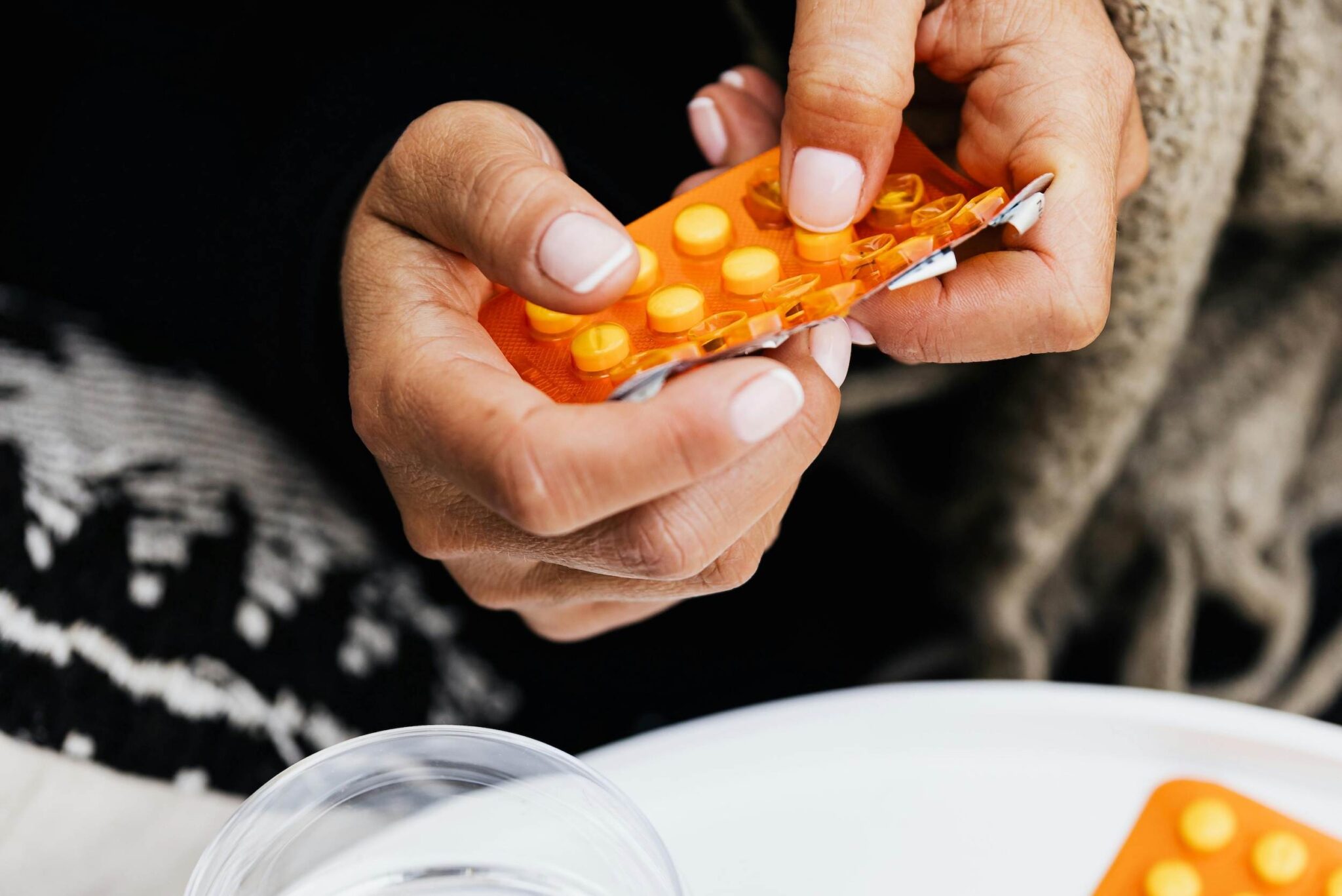 Woman holding HRT medication to help with her menopause symptoms.