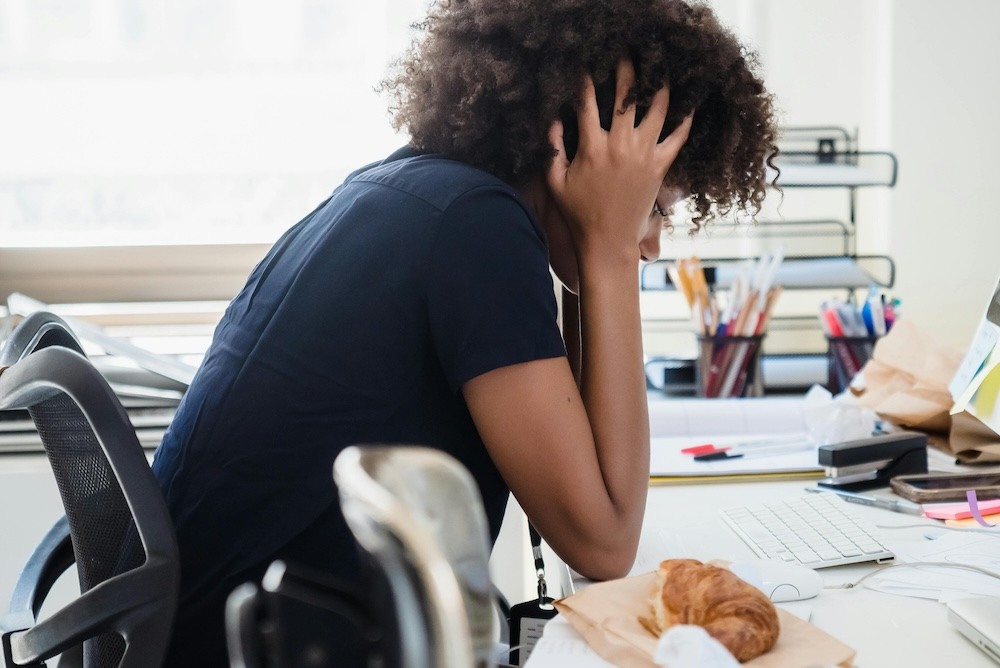 Perimenopausal woman struggling with brain fog in the workplace.