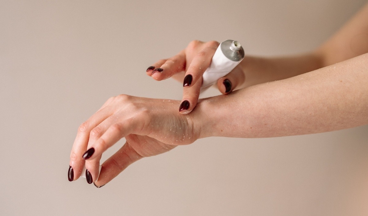 Patient rubbing prescription scabies cream on their hands.