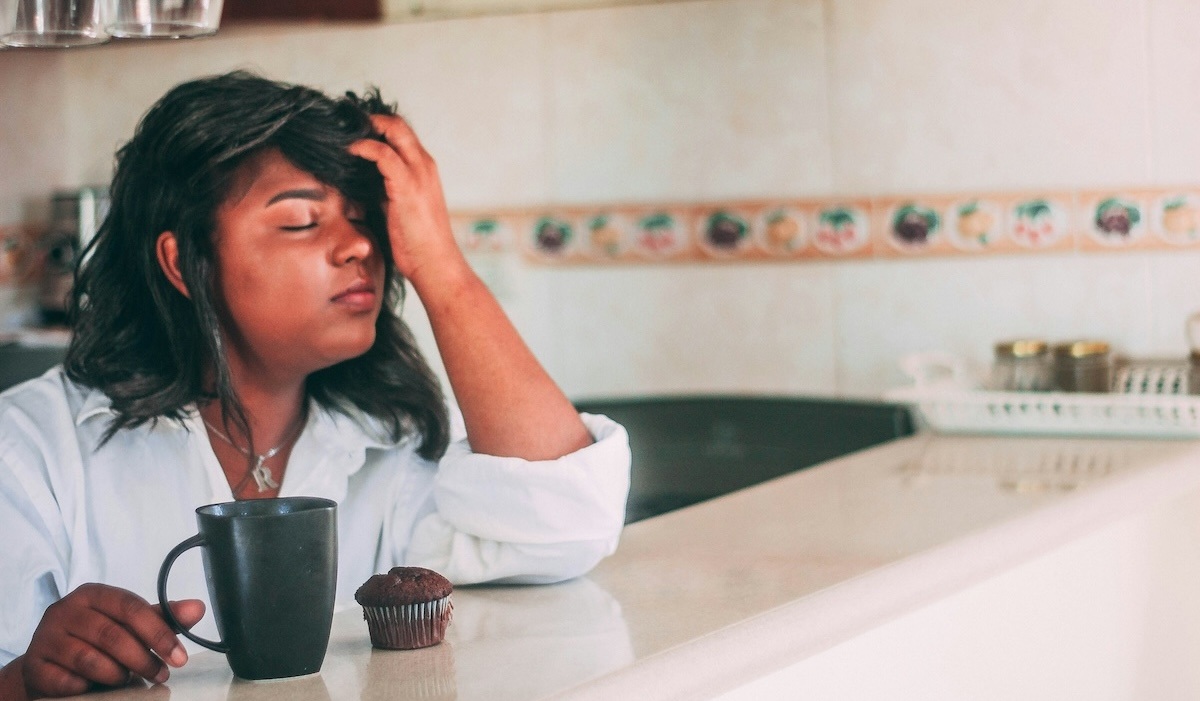 Woman experiencing a headache, which could be a sign of hypertension.