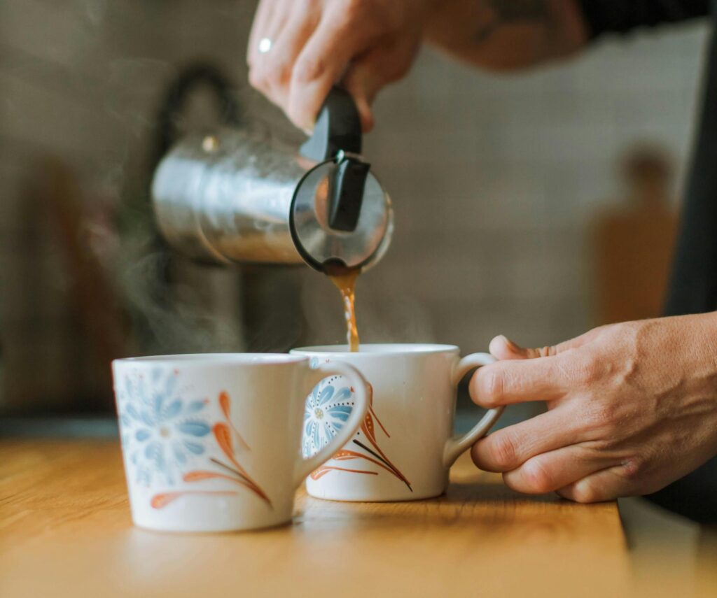 Man pouring a cup of hot tea for a natural cold remedy.