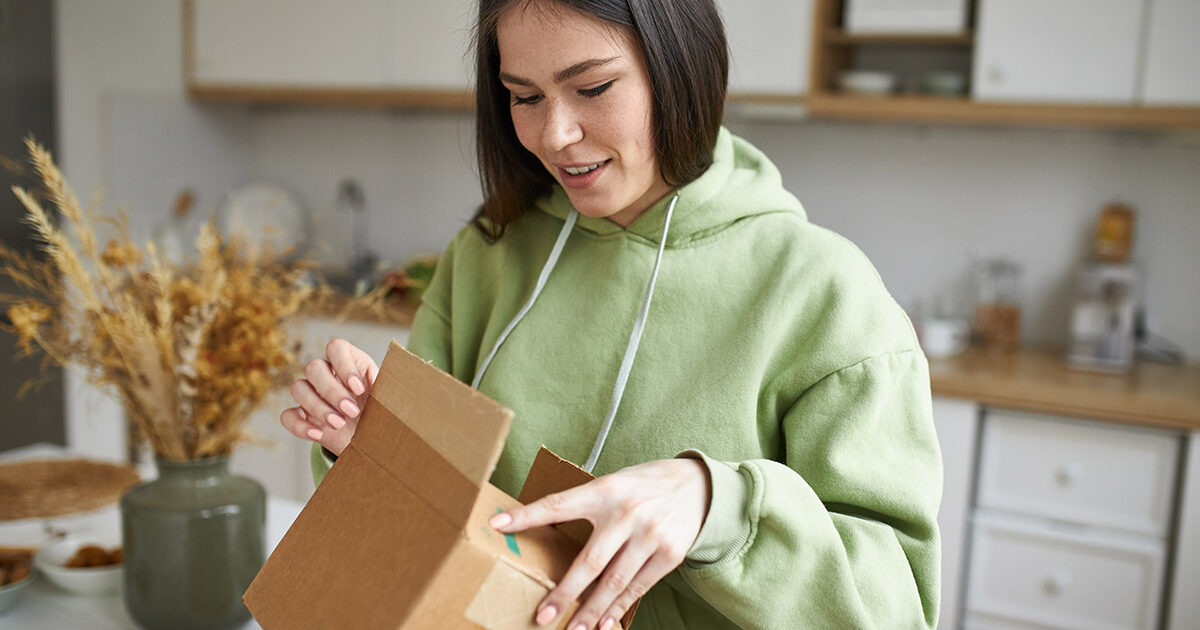 A woman receiving a package from a prescription delivery service.