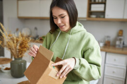 A woman receiving a package from a prescription delivery service.