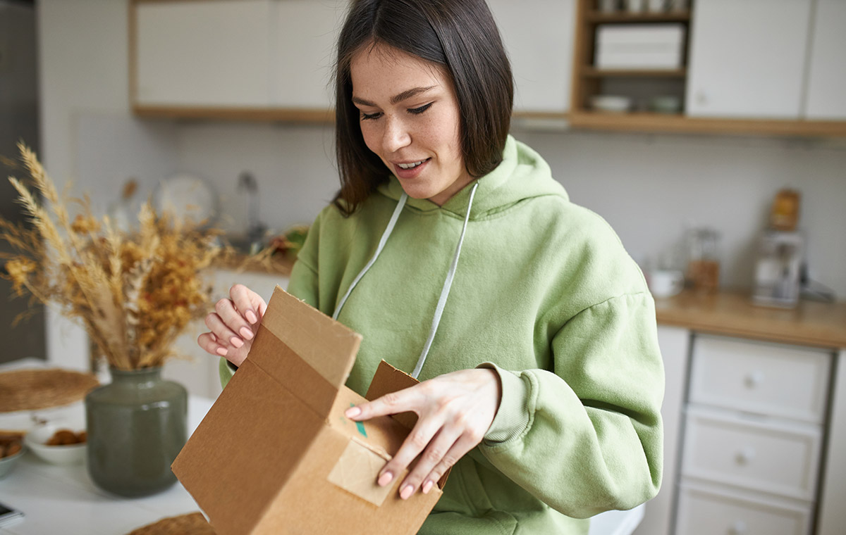 A woman receiving a package from a prescription delivery service.