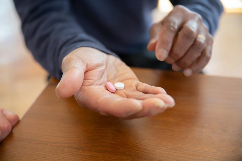 Closeup of hand with palm up holding two medication pills