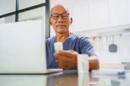 A man looking at his prescription bottle.