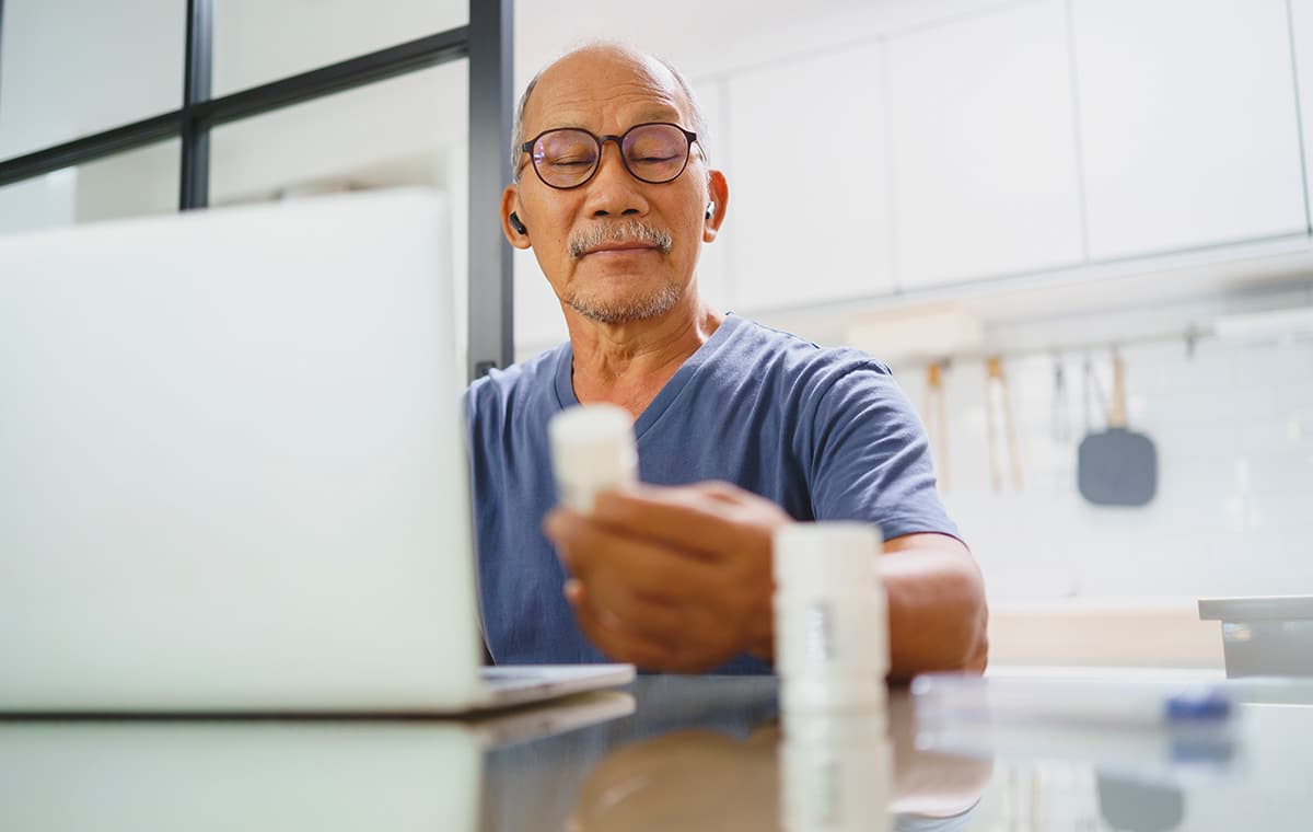 A man looking at his prescription bottle.