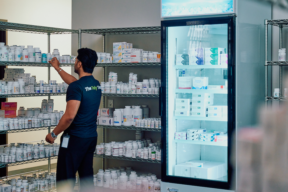 Pharmacy team member standing near medication storage