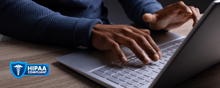 Hands typing on a laptop keyboard with security badge